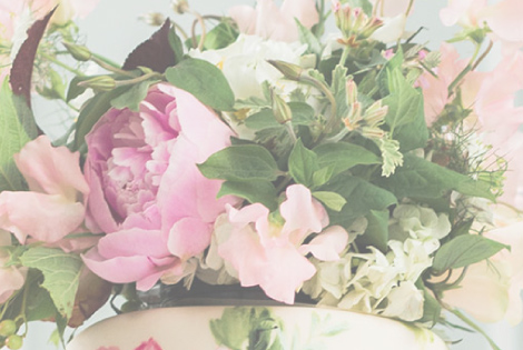 A close up photo of a floral topped wedding cake.